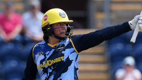 Lauren Parfitt of Glamorgan raises her bat to celebrate her fifty