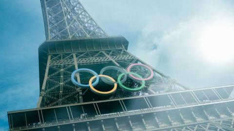 The Eiffel tower with the Olympic rings on, with the sun shining down on it