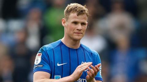 Rob Atkinson applauds fans at the end of a match for Portsmouth
