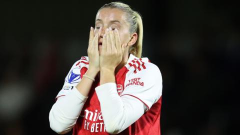 Arsenal striker Alessia Russo holds her hands to her face and looks dejected