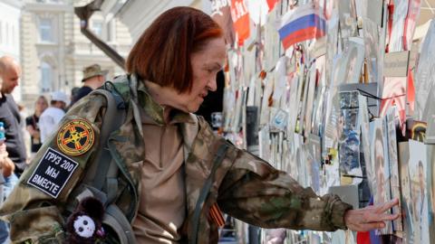 A woman stands in front of a makeshift memorial, which was erected following head of Russia's Wagner mercenary group Yevgeny Prigozhin and group commander Dmitry Utkin's death in 2023, during a commemoration ceremony held to pay tribute to Wagner fighters, who were recently killed in Mali by northern Tuareg rebels, in central Moscow, Russia August 4, 2024.