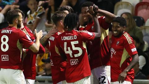 Adebola Oluwo (second right) of Salford City celebrates scoring a goal with team-mates