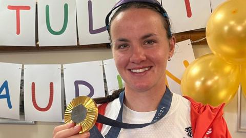 Lauren Henry with her Olympic gold medal after winning the women's quadruple sculls at the 2024 Games in Paris