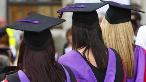 Three university students at a graduation ceremony