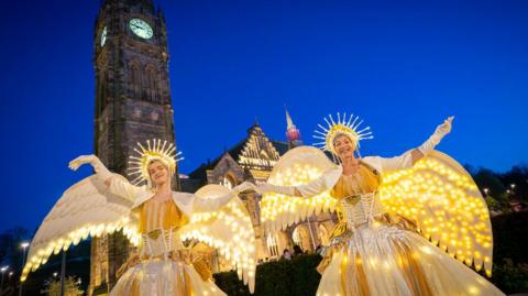 Two dancers dressed in illuminated bird costumes in Rochdale's 2025 Flight of Fancy parade