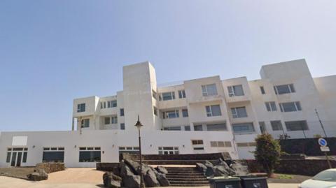 The outside of the Galeon Playa apartments. It is a white complex, with wide steps leading up the building. 