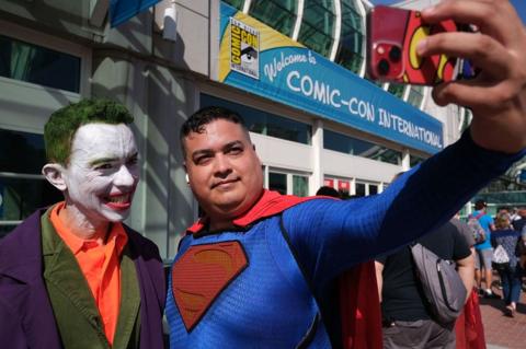 Men dressed as the Joker and Superman take a selfie