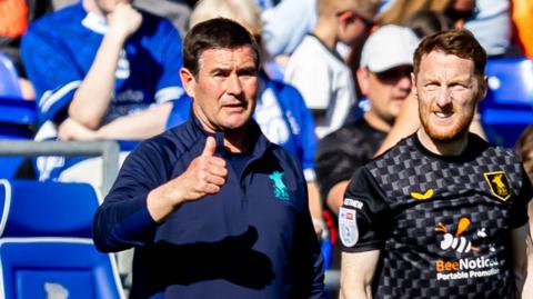 Mansfield boss Nigel Clough gives a thumbs up from the touchline during a match