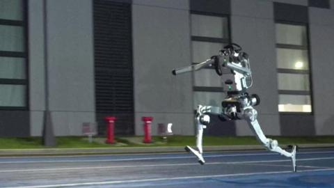 A humanoid robot runs on a track