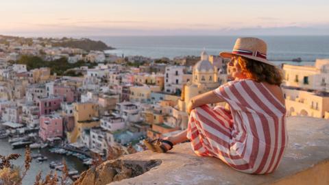 A woman admiring a sunset cityscape
