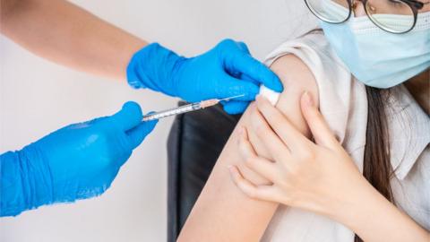 Young person being given vaccination stock image