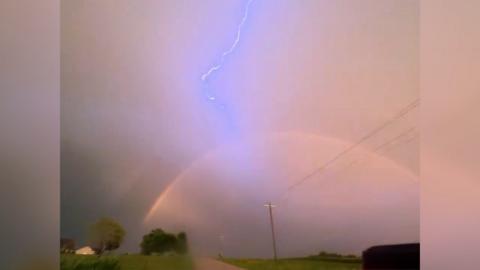 Lightning strikes over a rainbow in Iowa