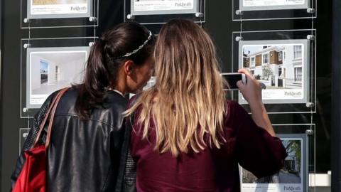 File photo of two women looking in an estate agent's window