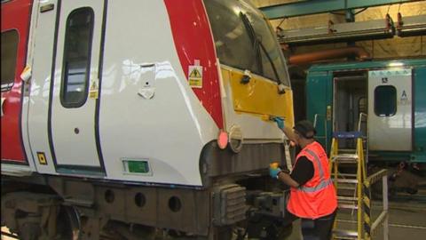 A train being painted with the Transport for Wales livery