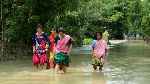 Women in Assam wade through knee-high water