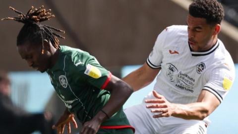 Ben Cabango of Swansea City (right) tackles Domingos Quina of Barnsley