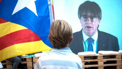 A child watches Carles Puigdemont on a screen at a rally in Amer, Girona, Catalonia, 16 July, 2023
