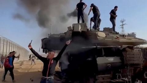 People stand on a tank in Gaza City