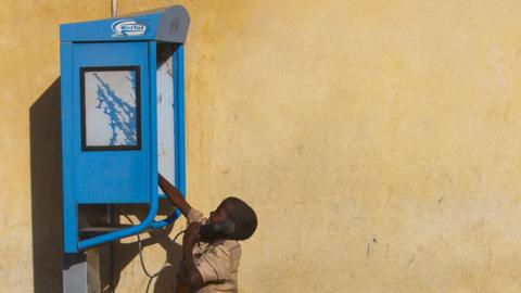 Boy using a pay phone in Asmara, 2013