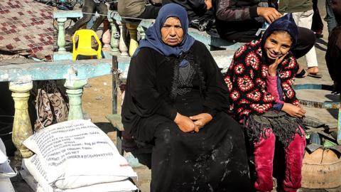 Displaced Palestinians receive flour bags at the United Nations Relief and Works Agency for Palestine Refugees (UNRWA) school in Rafah in the southern Gaza Strip on Sunday 28 January 2024