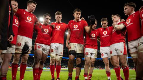 Wales players in a huddle after England defeat