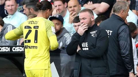 Derby boss Wayne Rooney watches keeper Kelle Roos leave the pitch after being sent off