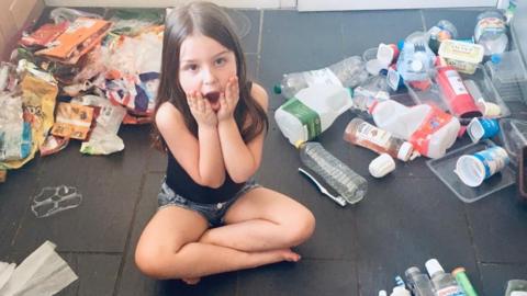 Ava Roberts with her family’s plastic waste