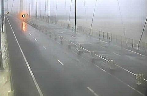 A traffic camera on the M48 Severn Bridge shows it closed with no traffic on it. The grey water of the River Severn can be seen below the bridge