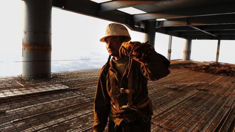 A Chinese worker makes his way along a construction project