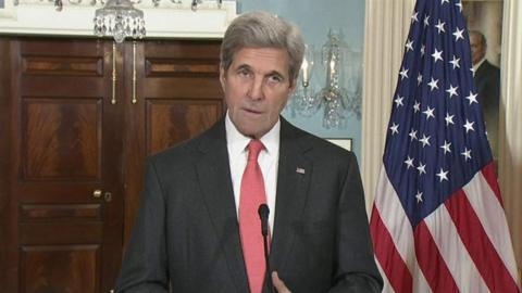 John Kerry stands by the US flag in Washington