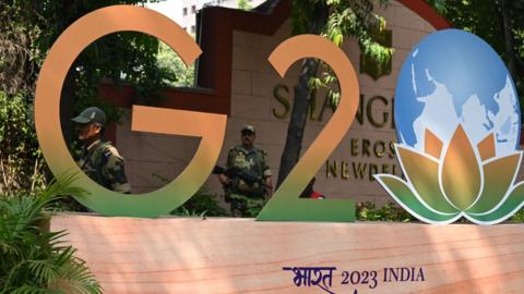 BSF security officials stand guard near a G20 Summit logo installed at Shangri-La Hotel as part of preparations for the upcoming G-20 India summit, on September 7, 2023 in New Delhi, India.