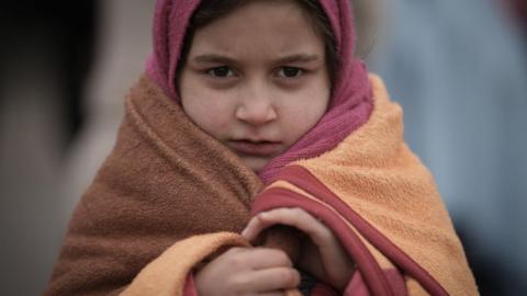 Refugee children fleeing Ukraine are given blankets by Slovakian rescue workers to keep warm at the Velke Slemence border crossing