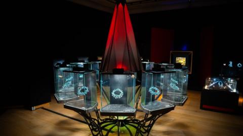 An exhibition that has a huge black diamond surrounded by smaller display pieces