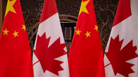 Canadian and Chinese flags are seen in Beijing