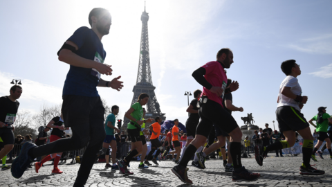 Paris Marathon runners pass the Eiffel Tower