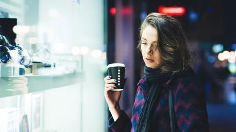 Woman window shopping at night