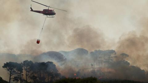 Helicopter drops water bomb on the fire