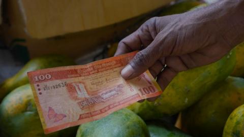 A vendor deals in rupee notes on March 21, 2023, in Colombo, Sri Lanka.