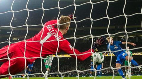 Caoimhin Kelleher gets across to make the save from Joel Pohjanpalo's penalty