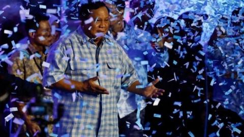 Presidential candidate Prabowo Subianto reacts while dancing as he claims victory after unofficial vote