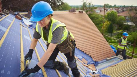 A female roofer at work on a house in the UK