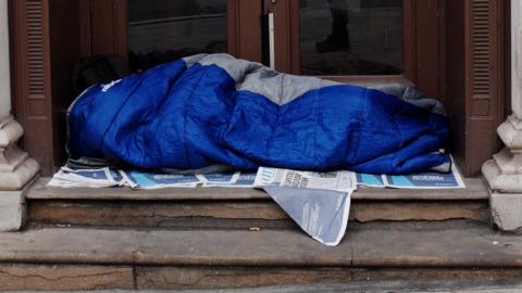 person sleeping at a door entrance