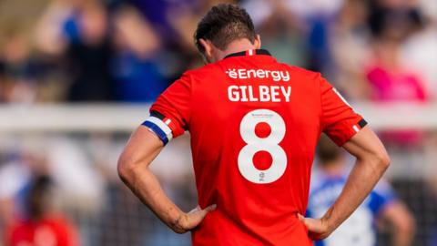 Alex Gilbey is dejected at the end of MK Dons' defeat at Gillingham