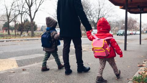 Man walking children to school