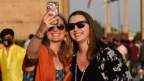 Foreign tourists are seen at India Gate monument