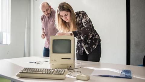 Members of staff show a Macintosh 128K, signed by Steve Wozniak, release date January 1984, at MacPaw's Ukrainian Apple Museum in Kiev, Ukraine on January 26, 2017
