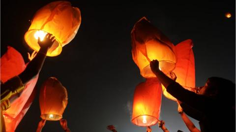People releasing lanterns into the sky