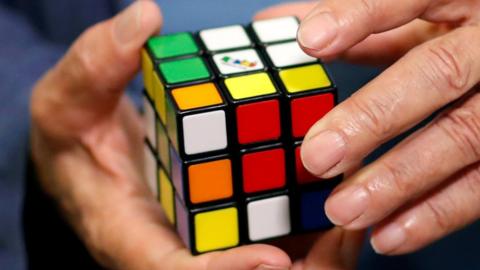 Erno Rubik, the creator of the puzzle, solves a Rubik's cube as he poses during the world's largest Rubik's Cube championship in Aubervilliers, near Paris, France,