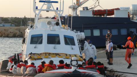 The patrol boat of the Italian Coast Guard loaded with rescued migrants arrive at the port in Lampedusa, Italy, 30 August 2020.