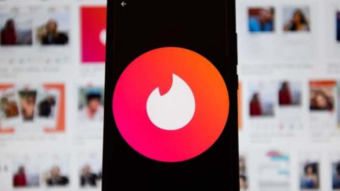 Tinder's logo displaying on a mobile phone.